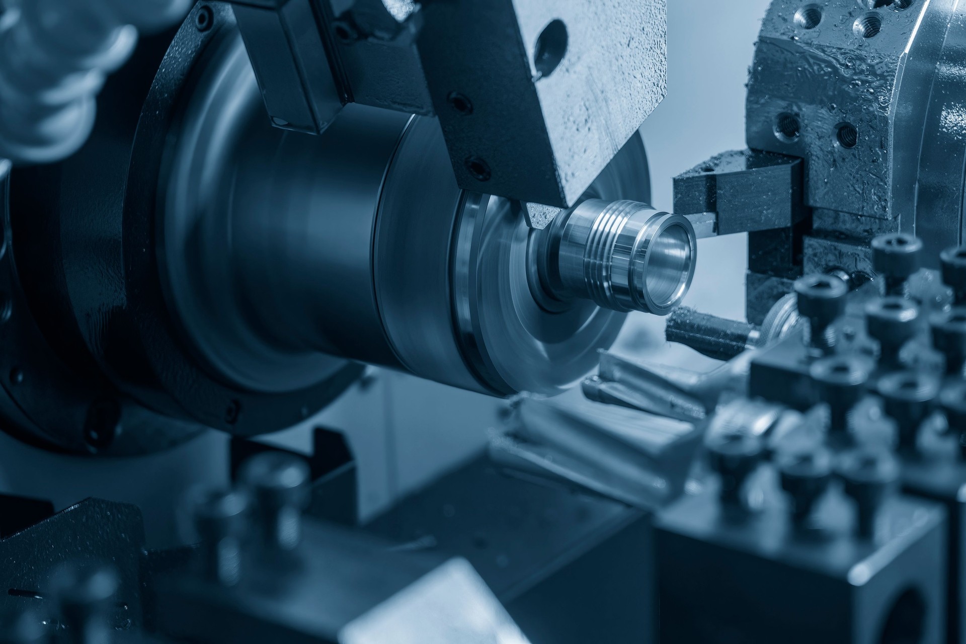 The multi-tasking CNC lathe machine swiss type thread cutting the metal pipe parts.
